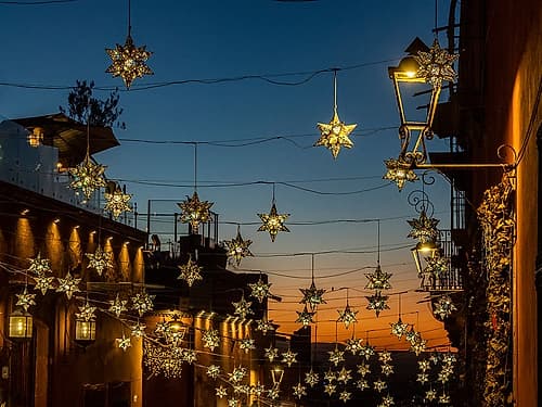 Mexico, San Miguel de Allende. Lighted stars suspended over a street at sunset. Art Print